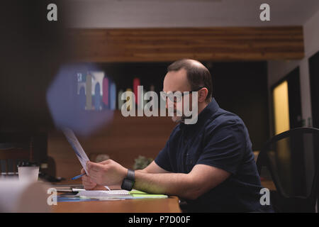 Male executive looking at graph document Stock Photo