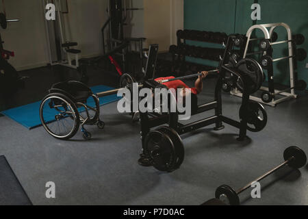 Handicapped man doing chest workout on bench press with barbell Stock Photo