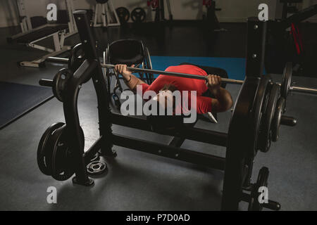 Handicapped man doing chest workout on bench press with barbell Stock Photo