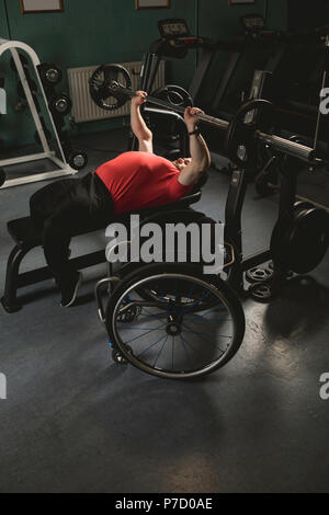 Handicapped man doing chest workout on bench press with barbell Stock Photo