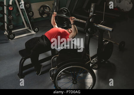 Handicapped man doing chest workout on bench press with barbell Stock Photo