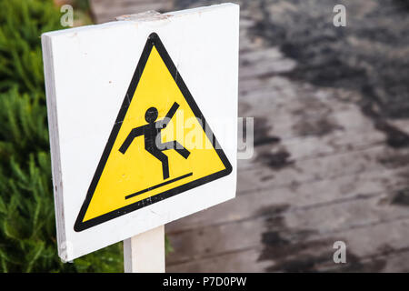 Caution wet floor, triangle warning sign on white board Stock Photo