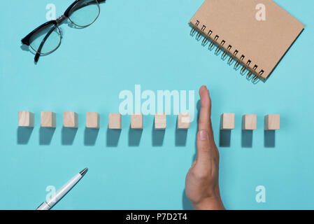 Hand of businessman stop dominoes continuous toppled Stock Photo