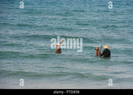 Mussel hunters, shellfish fishermen wearing straw hats, Cua Dai beach in  Hoi An, Vietnam Stock Photo - Alamy
