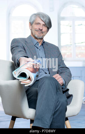 Man with magazine in an office Stock Photo