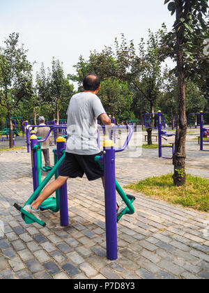 Man working out on the public equipment in the park of the Temple of Heaven, Beijing Stock Photo