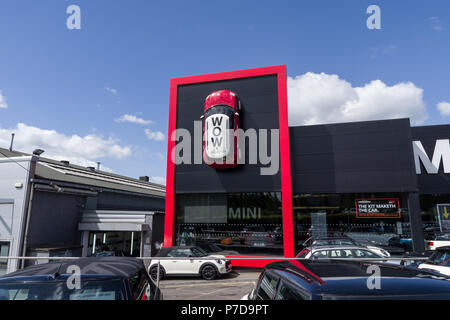 Frontage of Wollaston Mini car dealership with a Mini positioned high up on the wall; Northampton, UK Stock Photo