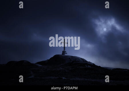 Mysterious cross in a hill against a cloudy full moon night Stock Photo