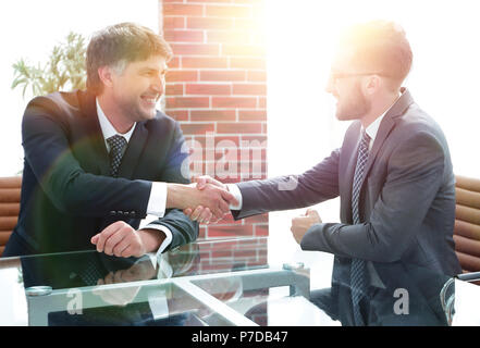 Business partners shake hands after discussing the contract Stock Photo