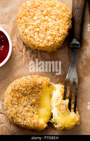 Fried camembert in golden poppy seed breadcrumb, with cranberry& apple sauce Stock Photo