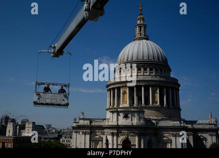 Window cleaners are suspended in a cradle above an office block next to St Paul's Cathedral, in Central London, Britain July 3, 2018. Stock Photo