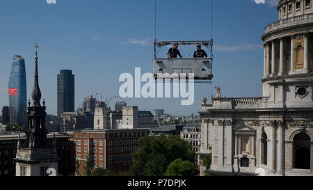 Window cleaners are suspended in a cradle above an office block next to St Paul's Cathedral, in Central London, Britain July 3, 2018. Stock Photo