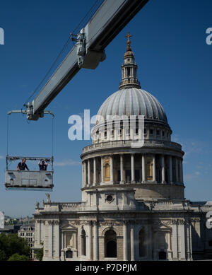 Window cleaners are suspended in a cradle above an office block next to St Paul's Cathedral, in Central London, Britain July 3, 2018. Stock Photo