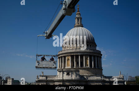 Window cleaners are suspended in a cradle above an office block next to St Paul's Cathedral, in Central London, Britain July 3, 2018. Stock Photo