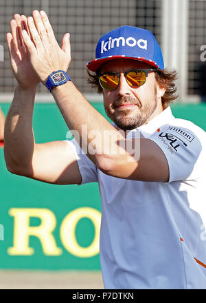 McLaren driver Fernando Alonso waves to fans as he walks on the track, during paddock day of the 2018 British Grand Prix at Silverstone Circuit, Towcester. PRESS ASSOCIATION Photo. Picture date: Thursday July 5, 2018. See PA story AUTO British. Photo credit should read: Martin Rickett/PA Wire. RESTRICTIONS: Editorial use only. Commercial use with prior consent from teams. Stock Photo