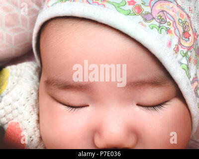 Cute Asian newborn baby girl napping in car seat on sunny day Stock Photo
