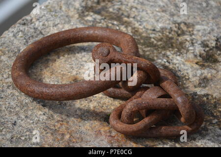 Rusty chain used to tie up boats on the quayside of a Cornish fishing village Stock Photo