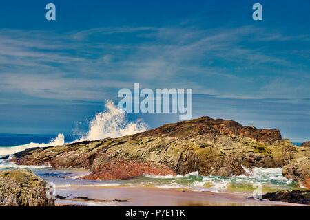 Waves breaking over rocks on the beach near Kearvaig, Scottish Highlands Stock Photo