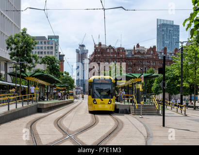 A modern yellow Metrolink trams stops at St Peters Square Station in the centre of Manchester Stock Photo