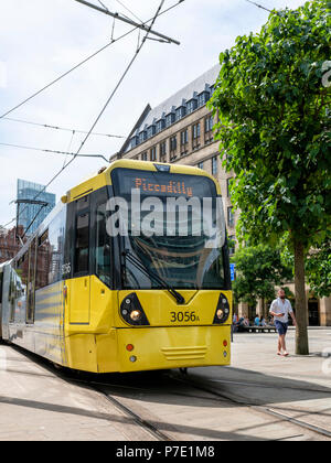 A modern yellow Metrolink trams stops at St Peters Square Station in the centre of Manchester Stock Photo