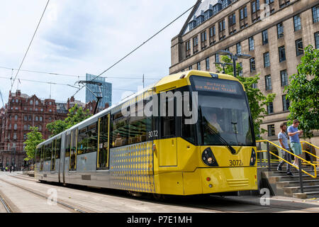 A modern yellow Metrolink trams stops at St Peters Square Station in the centre of Manchester Stock Photo