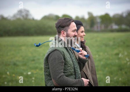 Woman and man dog walking in field Stock Photo