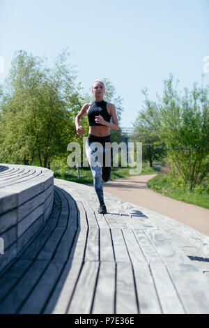 Young woman running in park Stock Photo