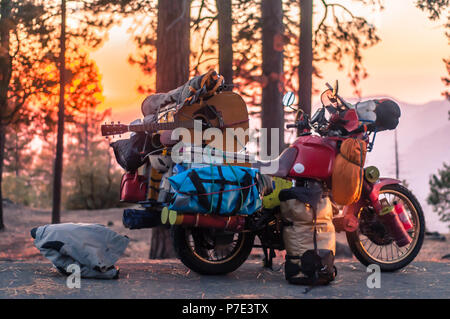 Part unloaded touring motorcycle parked on forest roadside at sunset, Yosemite National Park, California, USA Stock Photo