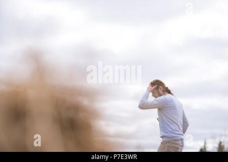 Man gardening with hand on forehead Stock Photo