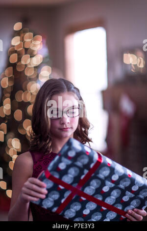 Portrait of girl holding christmas gift and smiling Stock Photo - Alamy