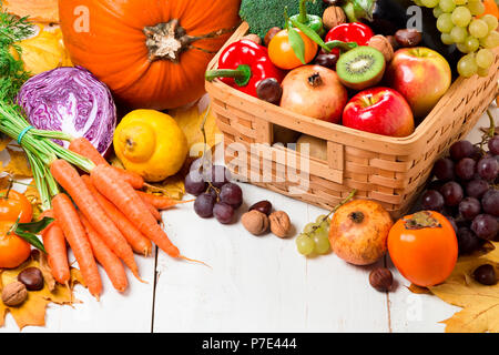 Assortment of fresh and ripe autumn vegetables and fruits on a rustic wooden table painted on white Stock Photo