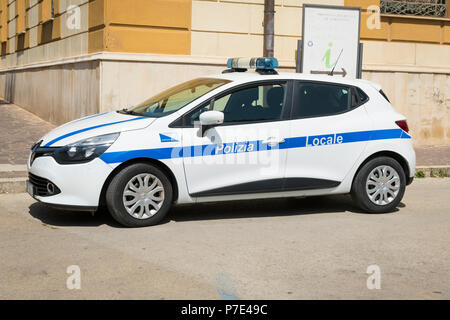 Italy Sicily Agrigento modern police car white blue stripe Polizia Locale Renault Clio blue lights parked cobble cobbled street road Stock Photo