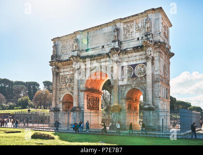 Italy, Rome, March 9/ 2018, tourists walking around the Arch of Constantine, Colosseum in the background Stock Photo