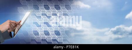 Hand using tablet with geometric transition of sky Stock Photo