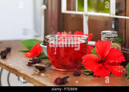 Red karkade hibiscus red sorrel tea in glass mug with dry tea cu Stock Photo
