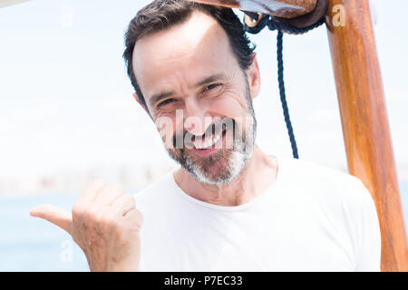 Handsome senior man traveling on sailboat pointing with hand and finger up with happy face smiling Stock Photo