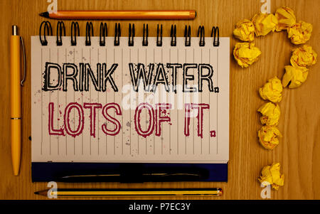 Text sign showing Drink Water. Lots Of It. Conceptual photo drinking liquids to keep our body in great status Notepad with outline text pen pencil woo Stock Photo