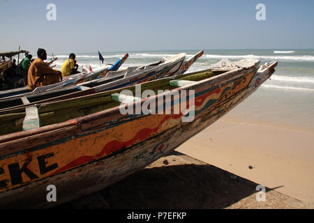 Sahelian fishermen sitting in their colorful painted pirogues and looking towards the Atlantic Ocean Stock Photo