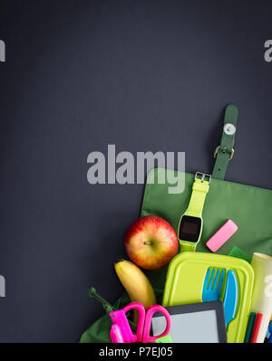 Backpack with school supplies on black background. Top view Flat lay Stock Photo