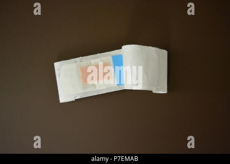 White bactericidal plaster for wounds on brown matte background. Stock Photo