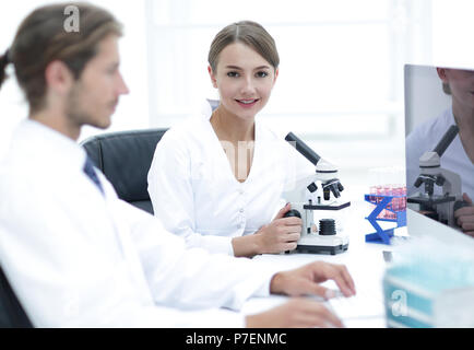 Lab expert working on a test using microscope Stock Photo