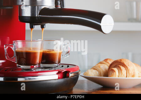 Hot espresso running into two cups. Making espresso in glass transparent coffee  cup. Stock Photo
