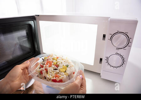 Cooking, heating food in the microwave. Baked potatoes with meat,  vegetables on a white plate in the microwave top view Stock Photo - Alamy