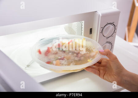 Cooking, heating food in the microwave. Baked potatoes with meat,  vegetables on a white plate in the microwave top view Stock Photo - Alamy