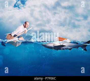 Businessman on a cardbox in the ocean looks for an help. Help with deception concept Stock Photo