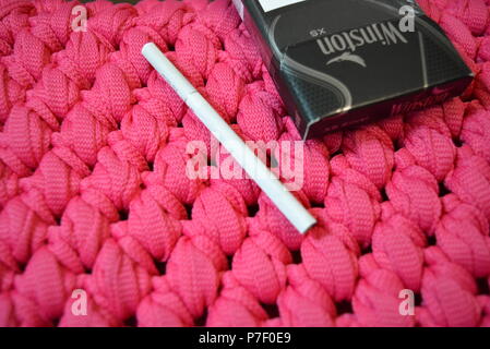 skinny pink cigarettes White thin cigarette with XS filter and packaging on a pink background  Stock Photo