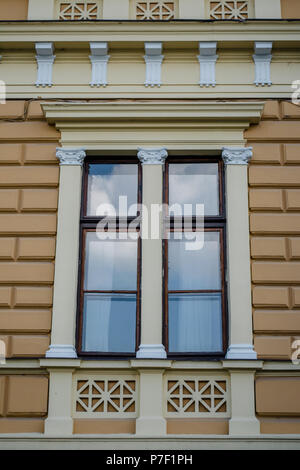 A window with bas-relief on facade. Decorative window frames. Stock Photo