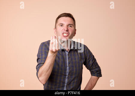 Caucasian middle aged man looking angry showing italian gesture over brown background Stock Photo