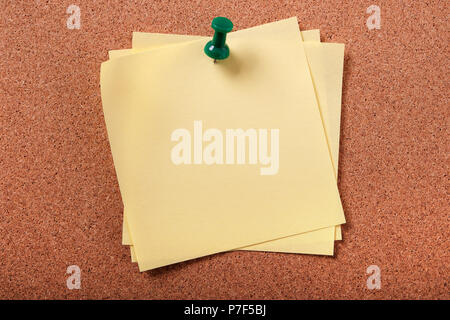 Several untidy sticky post notes pinned to cork board Stock Photo