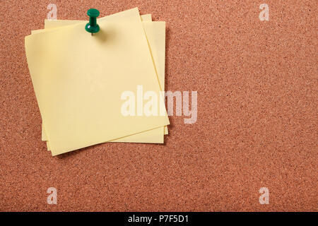 Several untidy sticky post notes pinned to cork board copy space Stock Photo
